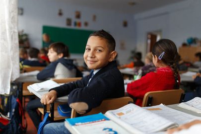 Um menino sorridente em seu primeiro dia de volta à escola